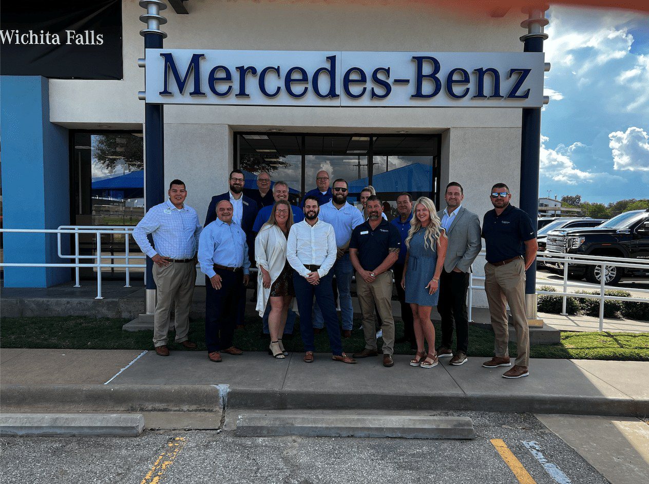 A Group of People Outside a Building With Mercedes Board