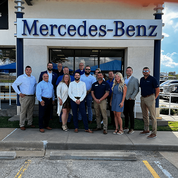 A Group of People Standing Outside a Mercedes Store